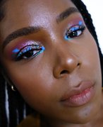 A close-up picture of a black makeup artist wearing colorful eyeshadow