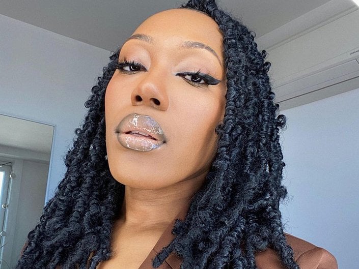 Person with ombré glossy lipstick and butterfly locs.