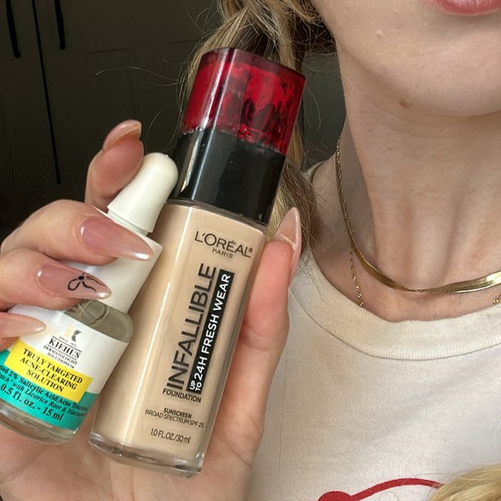 Close-up picture of the editor holding the liquid pimple patch and foundation