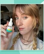 Picture of an editor holding the Kiehl’s Truly Targeted Acne-Clearing Pimple Patch with Salicylic Acid on a turquoise graphic background