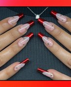 A person’s hands with a manicure featuring red chrome French tips. 