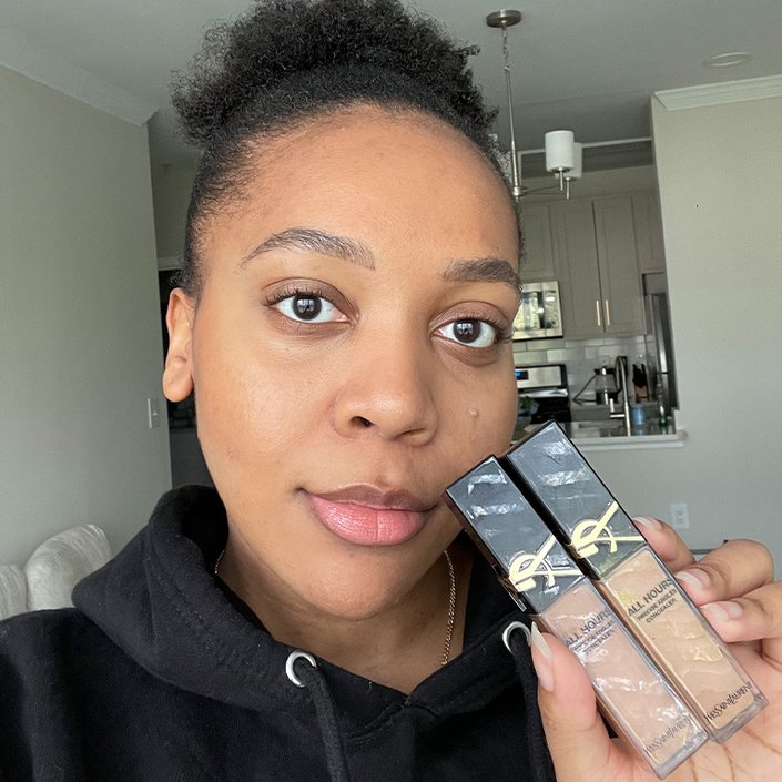 Kat wearing and holding up the YSL Beauty All Hours Creaseless Precise Angles Concealer in MW9 and DN1